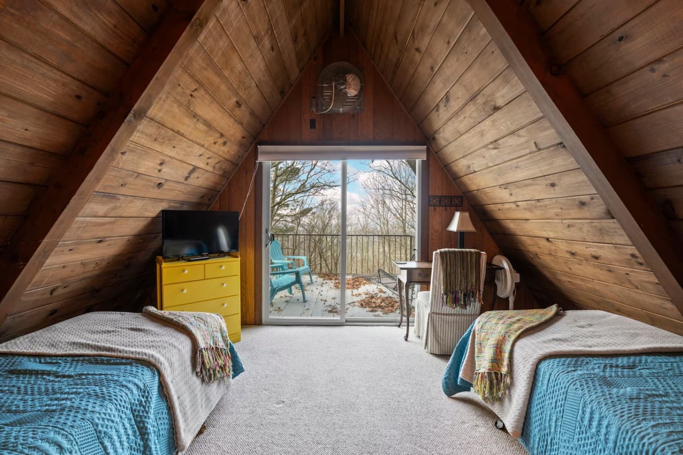 Charming loft bedroom with two twin beds and a private balcony.