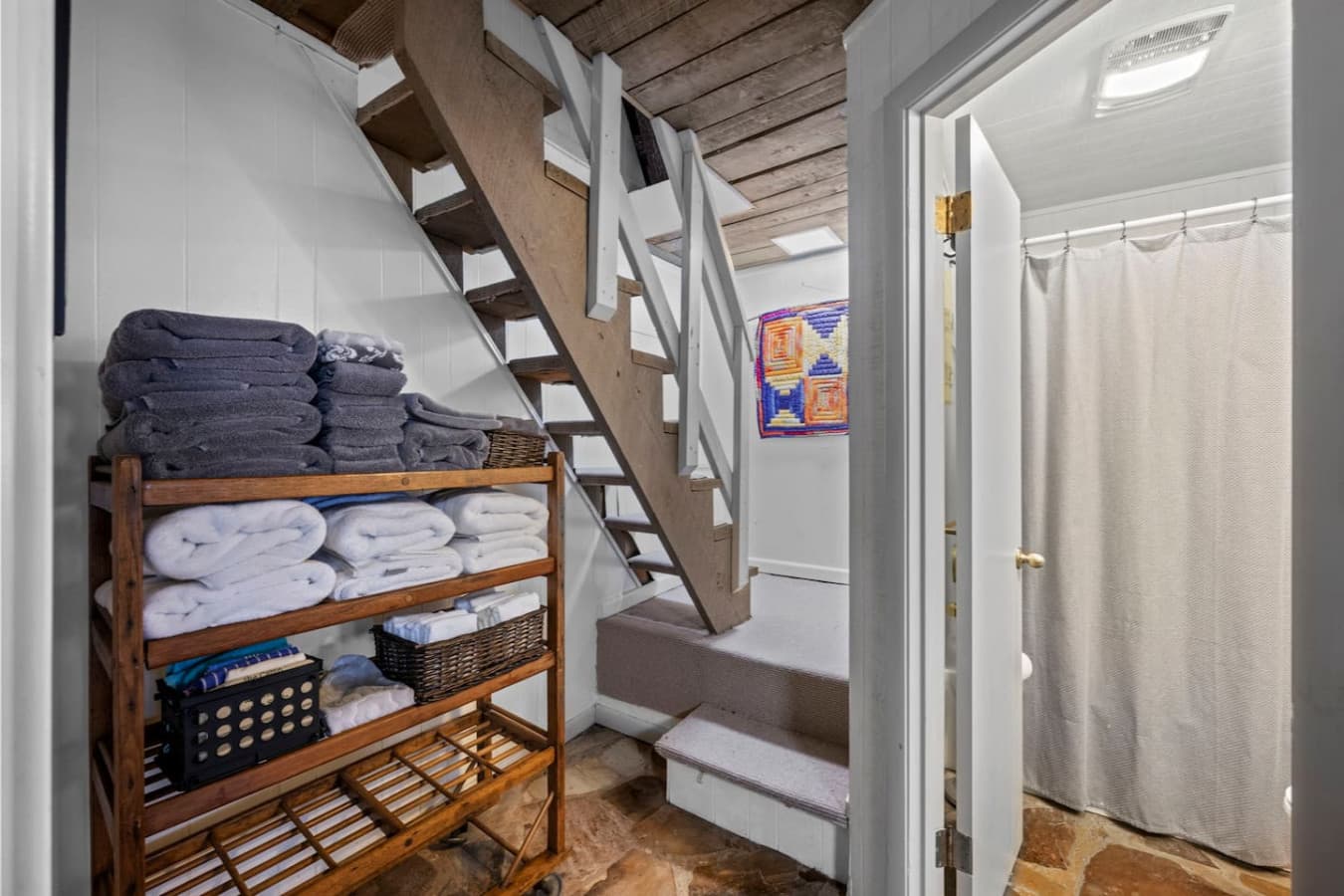 The stairs to the main level from downstairs. Half bathroom to the right.