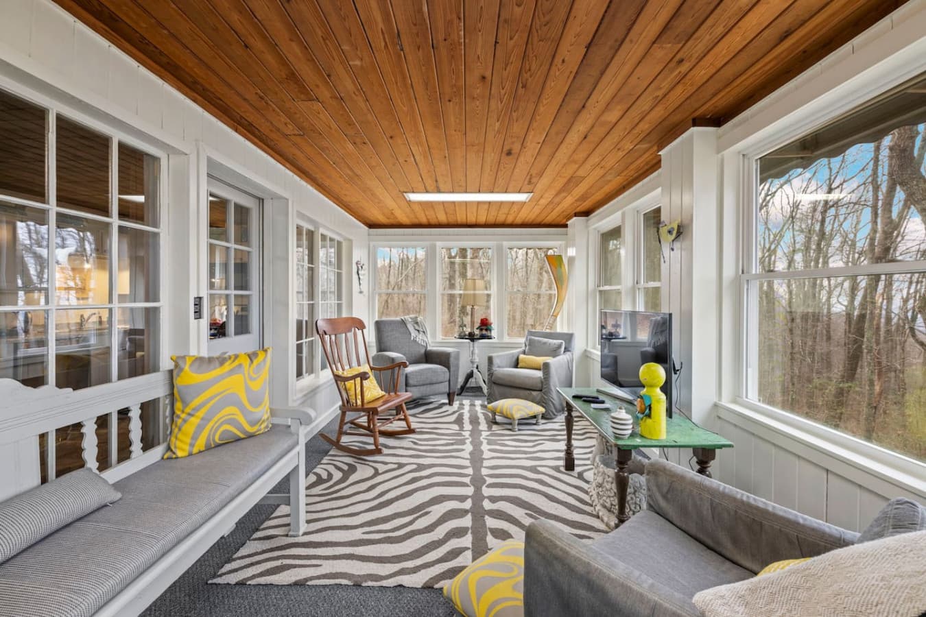 A tranquil, enclosed porch designed for year-round comfort and relaxation.