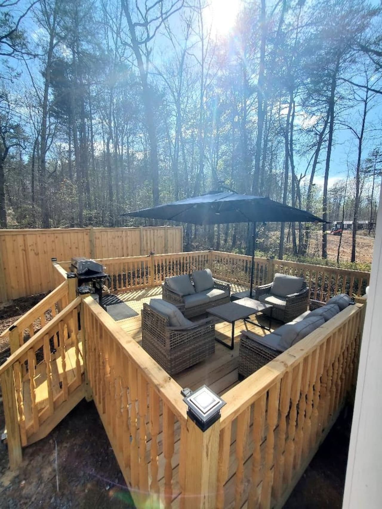 Spacious deck with comfy seating, shade, and a grill—perfect for outdoor gatherings.