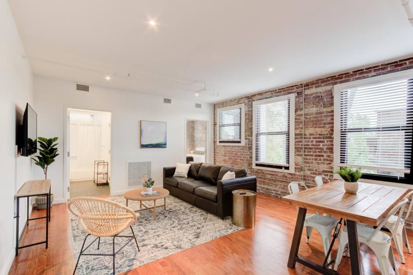 Light-filled living space with seating & table. Large windows fill the space with natural light, creating an uplifting and energizing atmosphere.