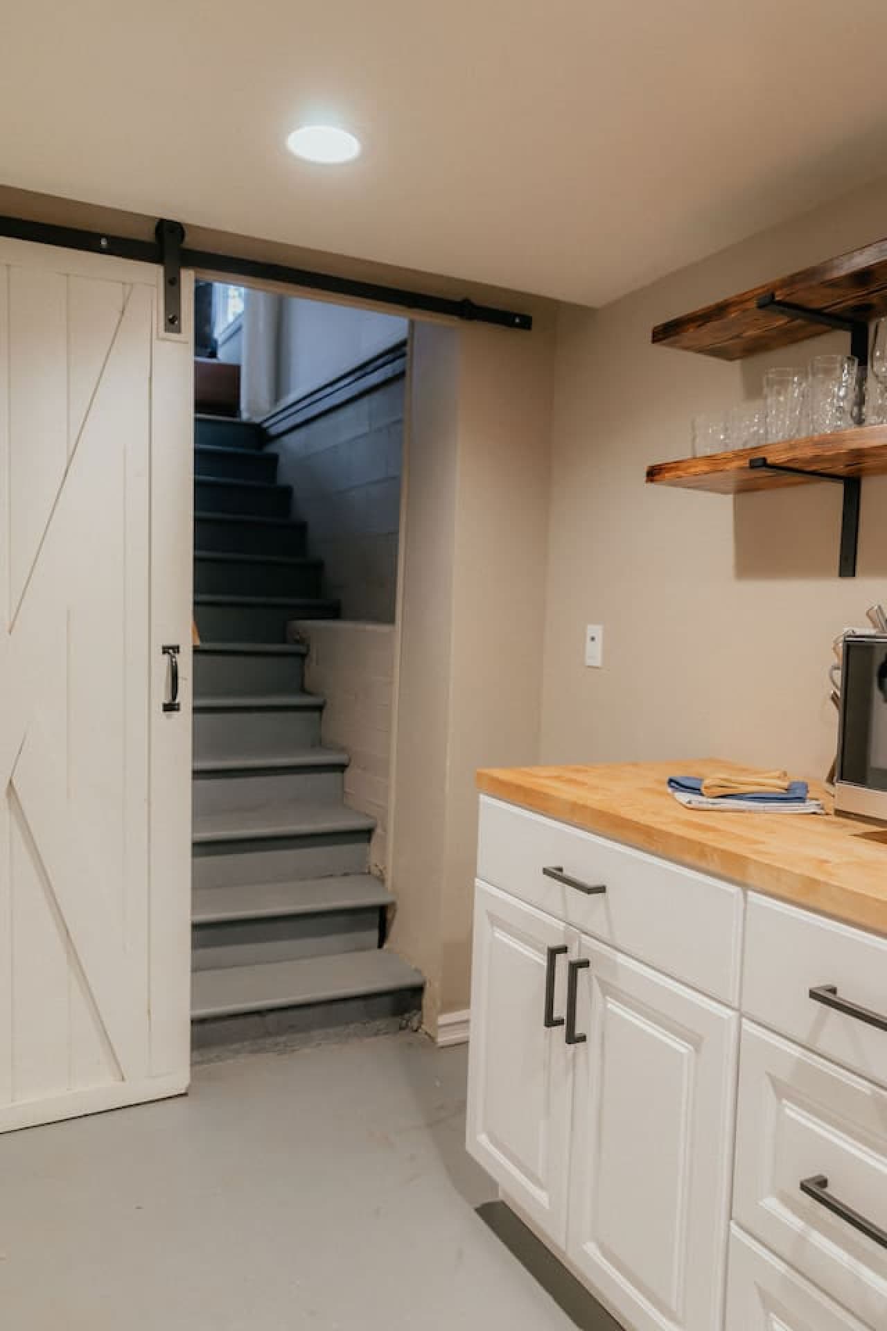 Stairs going up the main level from the kitchenette/laundry area.