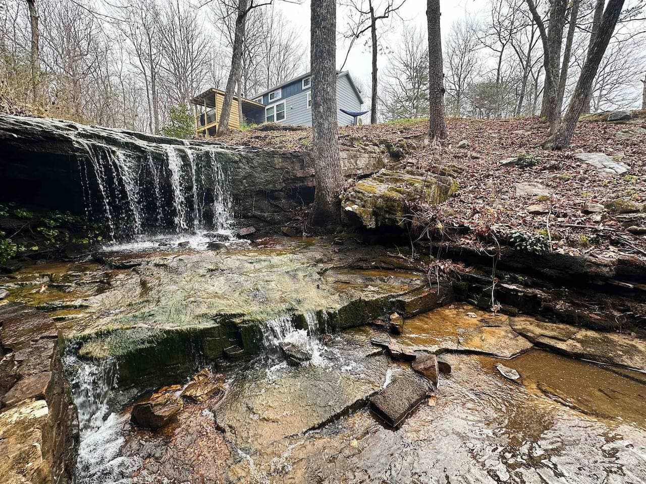Blueberry Falls features a peaceful setting with a small waterfall, creek, and pond, offering a relaxing natural backdrop for your stay.