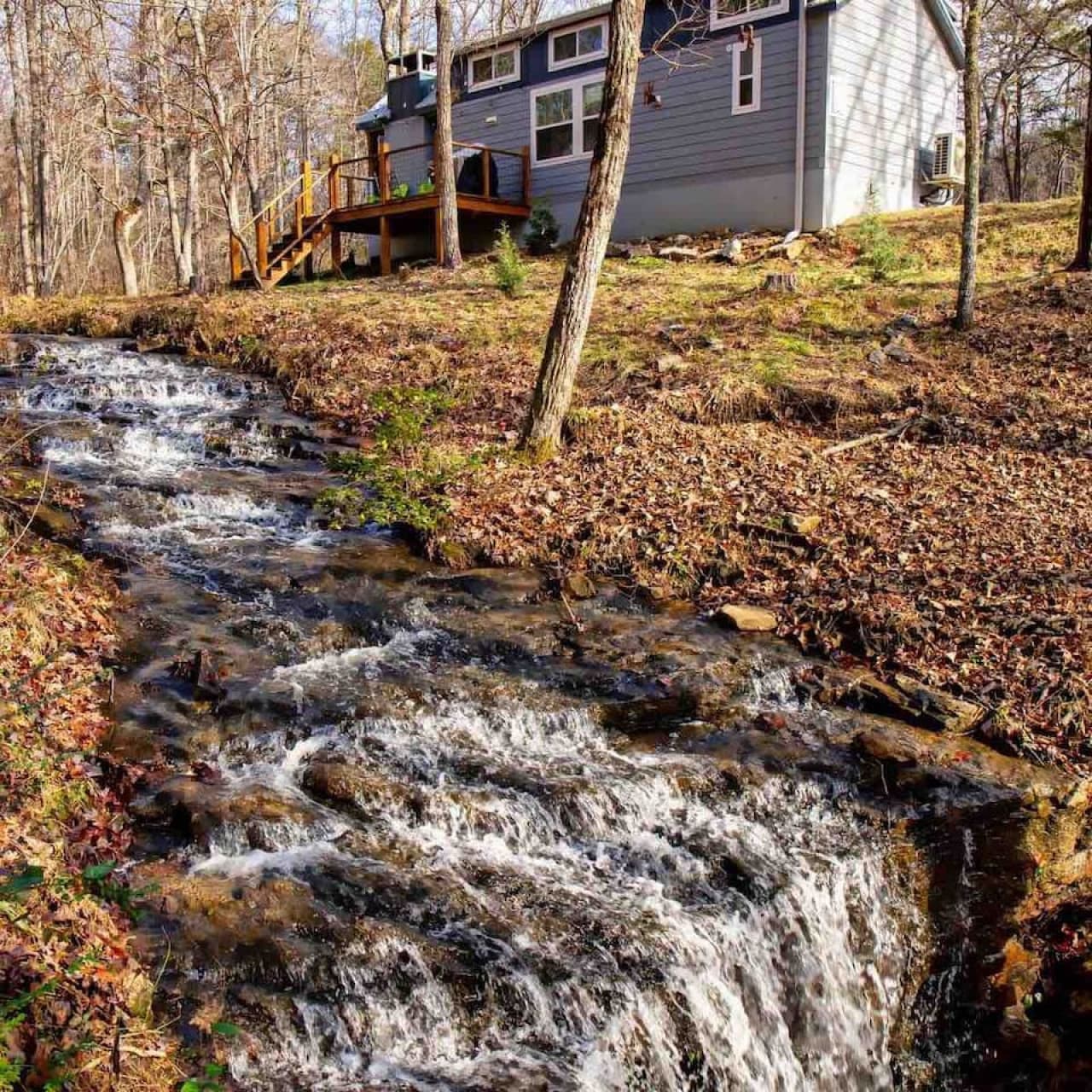 A peaceful creek and waterfall flow just behind the cottage, creating a tranquil natural setting.