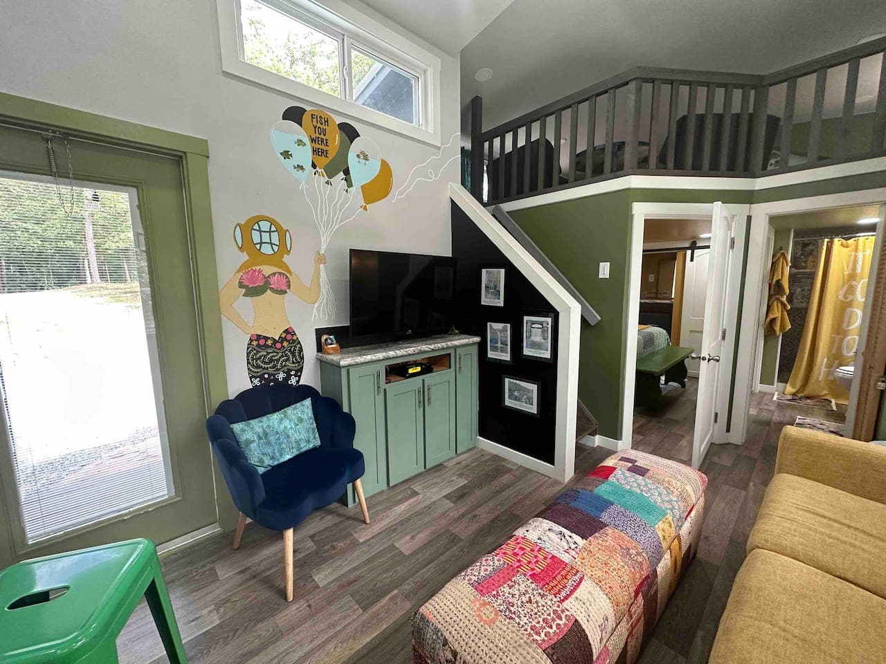 The living room features a Smart TV and a hand-painted mural created by a local artist.