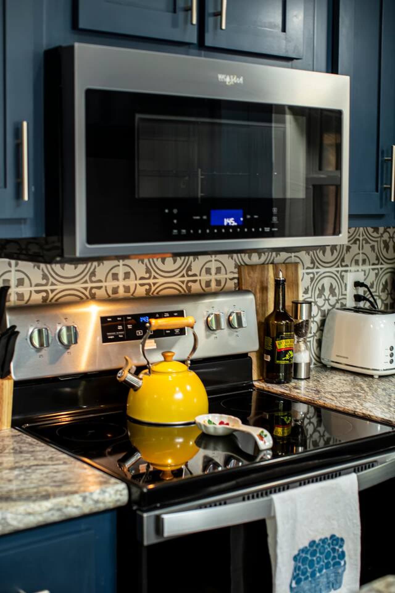 The kitchen includes a microwave, electric stove, and tea kettle, with salt, pepper, and olive oil provided for your convenience.