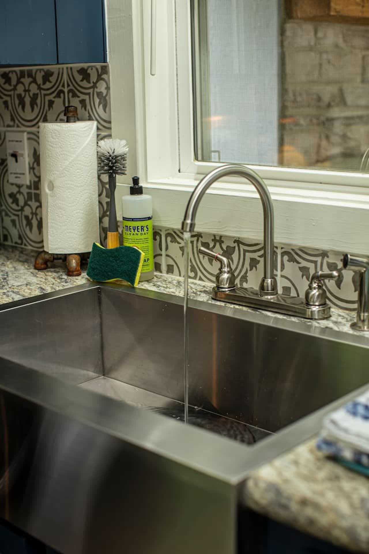 The kitchen includes a stainless farmhouse sink with a sponge, dish soap, and one roll of paper towels provided.