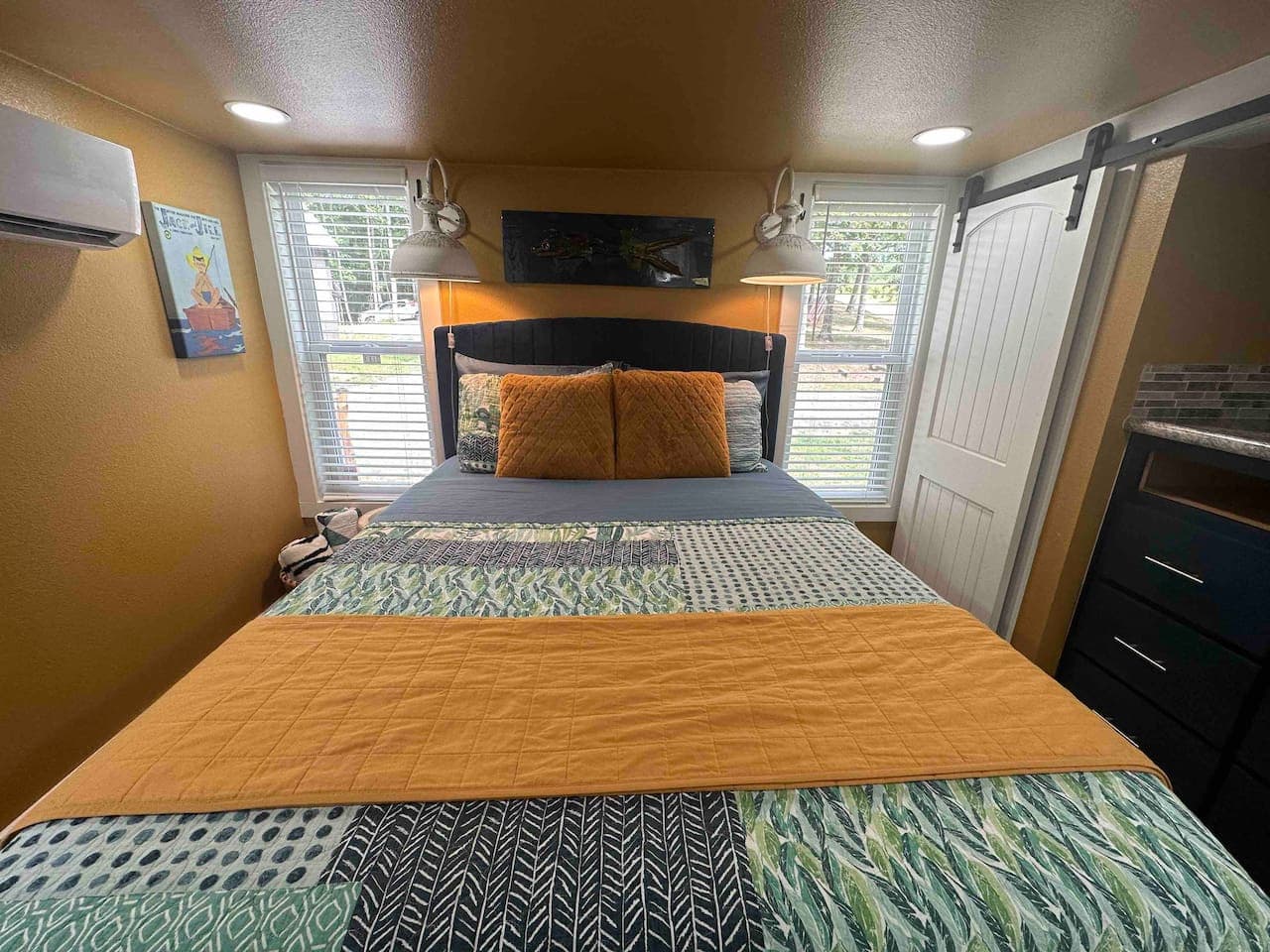 The master bedroom features a queen bed with linens provided, including a sheet set, quilt, and two pillows, along with a double closet and drawers for storage.
