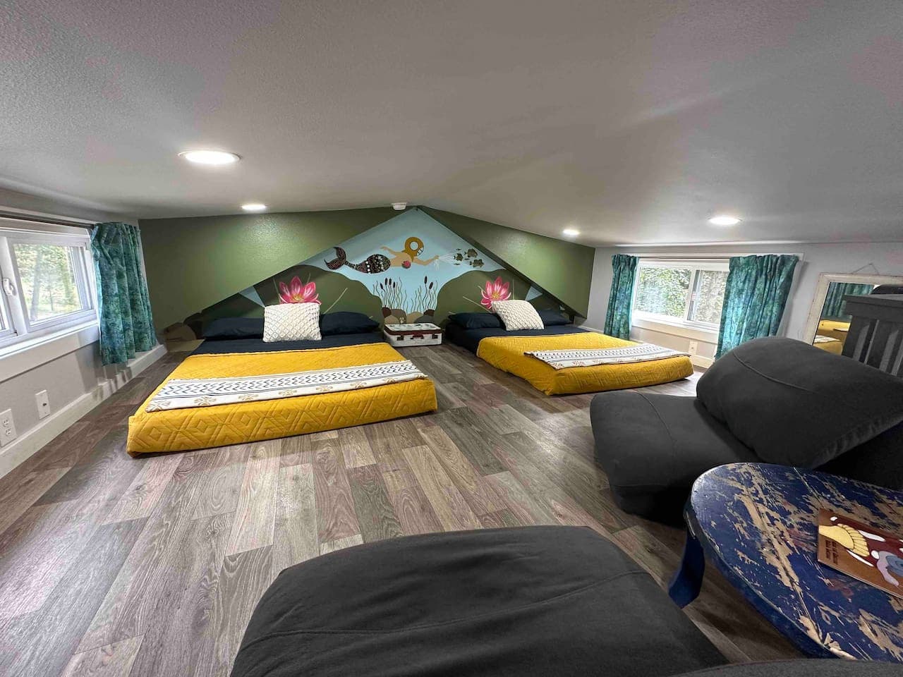 Bedroom 2 (Loft) includes views of the waterfall and creek, along with a cozy sitting area featuring two floor chairs and a table.