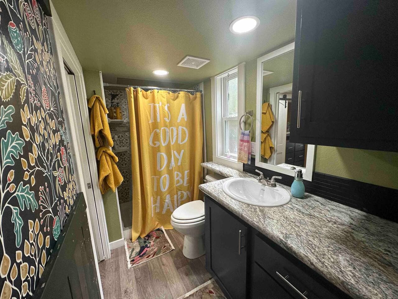 The full bathroom includes a shower, toilet, and vanity with storage cabinets and drawers. Essentials such as shampoo, conditioner, body wash, a hair dryer, and one towel and washcloth per guest are provided.