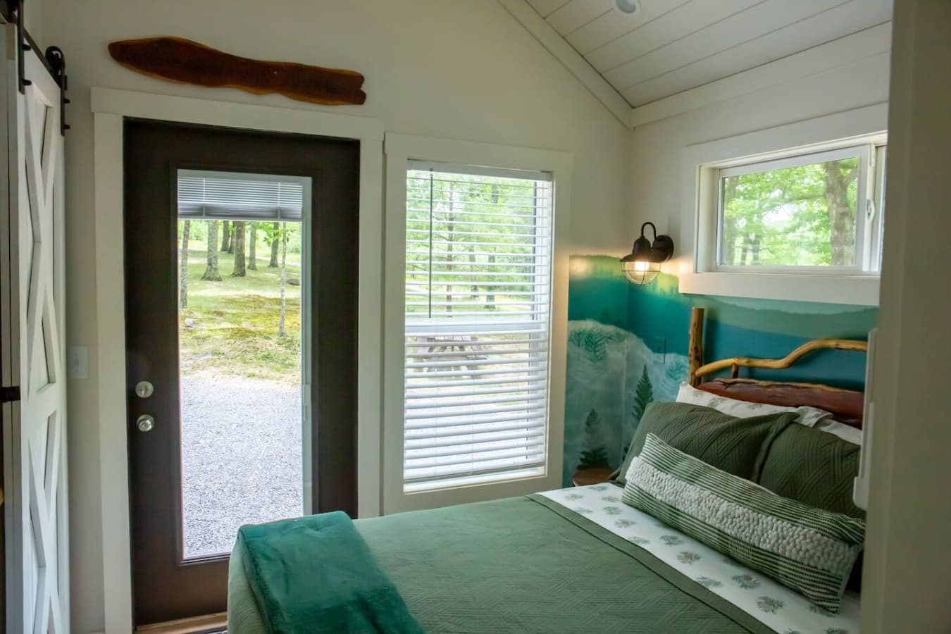 The master bedroom features ample windows and a windowed door that fill the space with natural light and peaceful views.