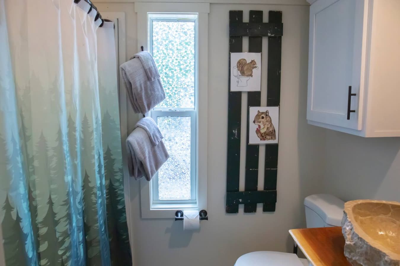 The bathroom features a full bath with a shower and includes towels, shampoo, conditioner, body wash, hand soap, and two rolls of toilet paper for your stay.