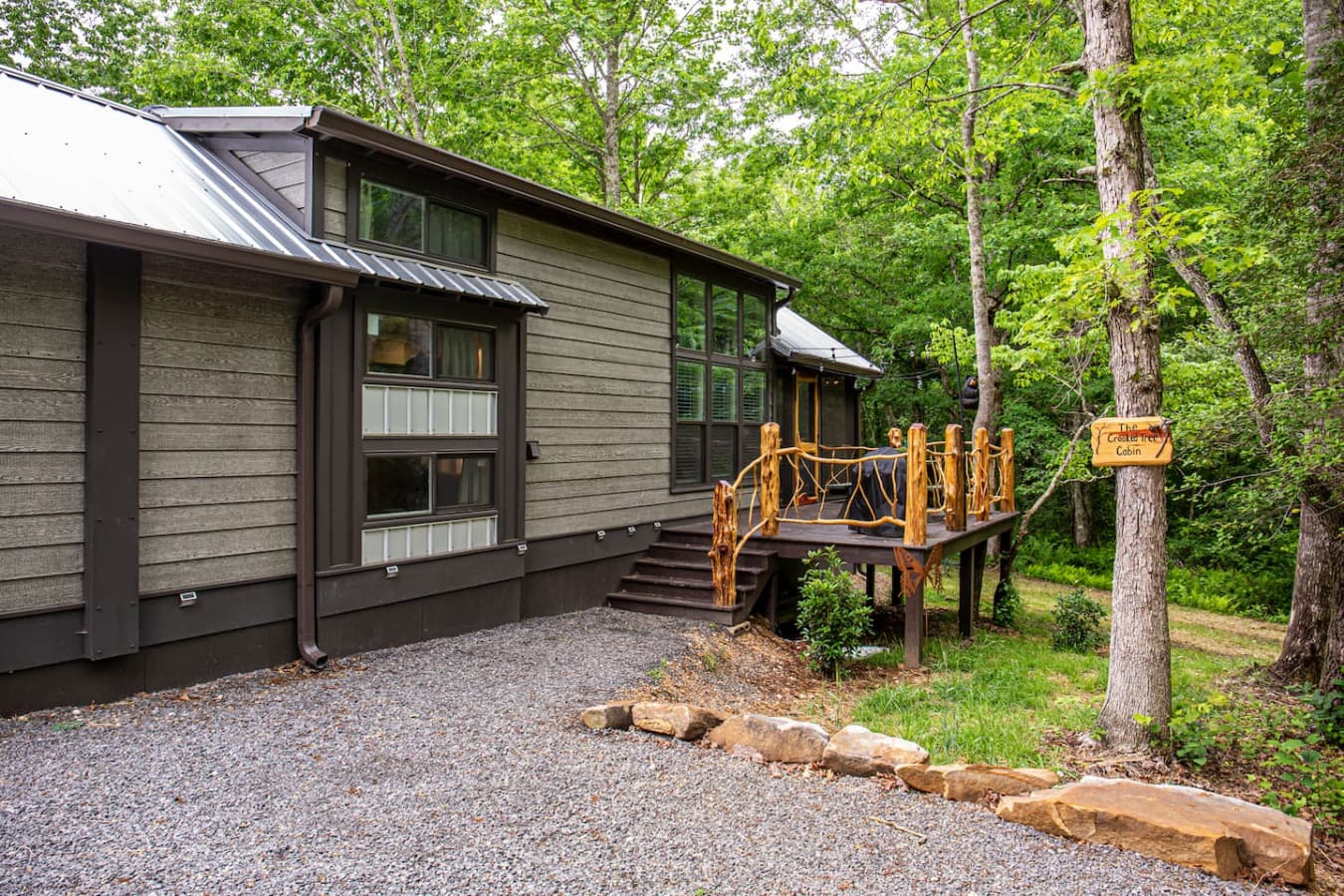 The cabin’s exterior blends rustic charm with natural beauty—surrounded by trees, creek views, and the peaceful sounds of Blueberry Falls Farm.