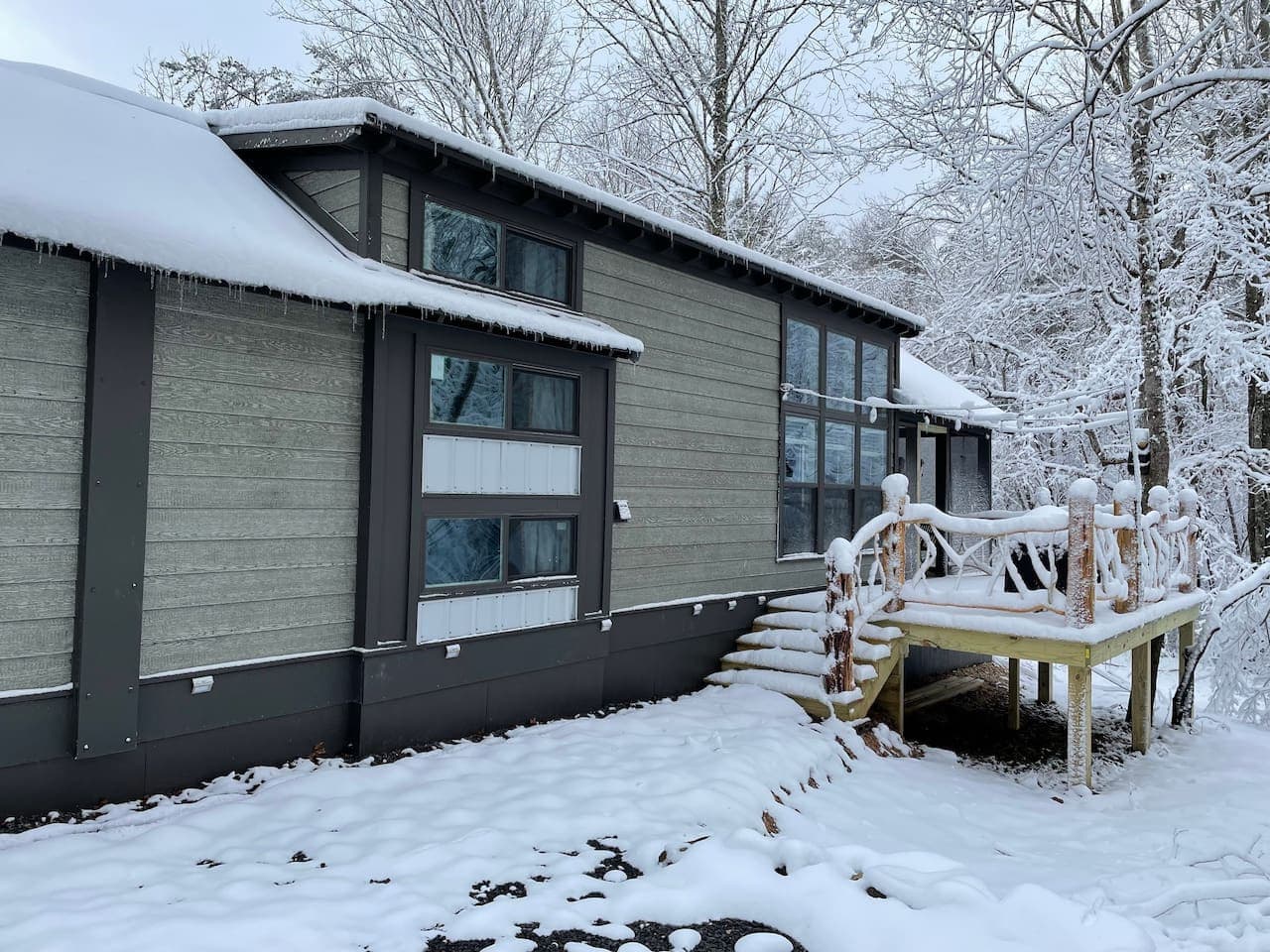 A snowy day at the farm transforms the cabin into a serene winter wonderland, blanketed in quiet beauty.