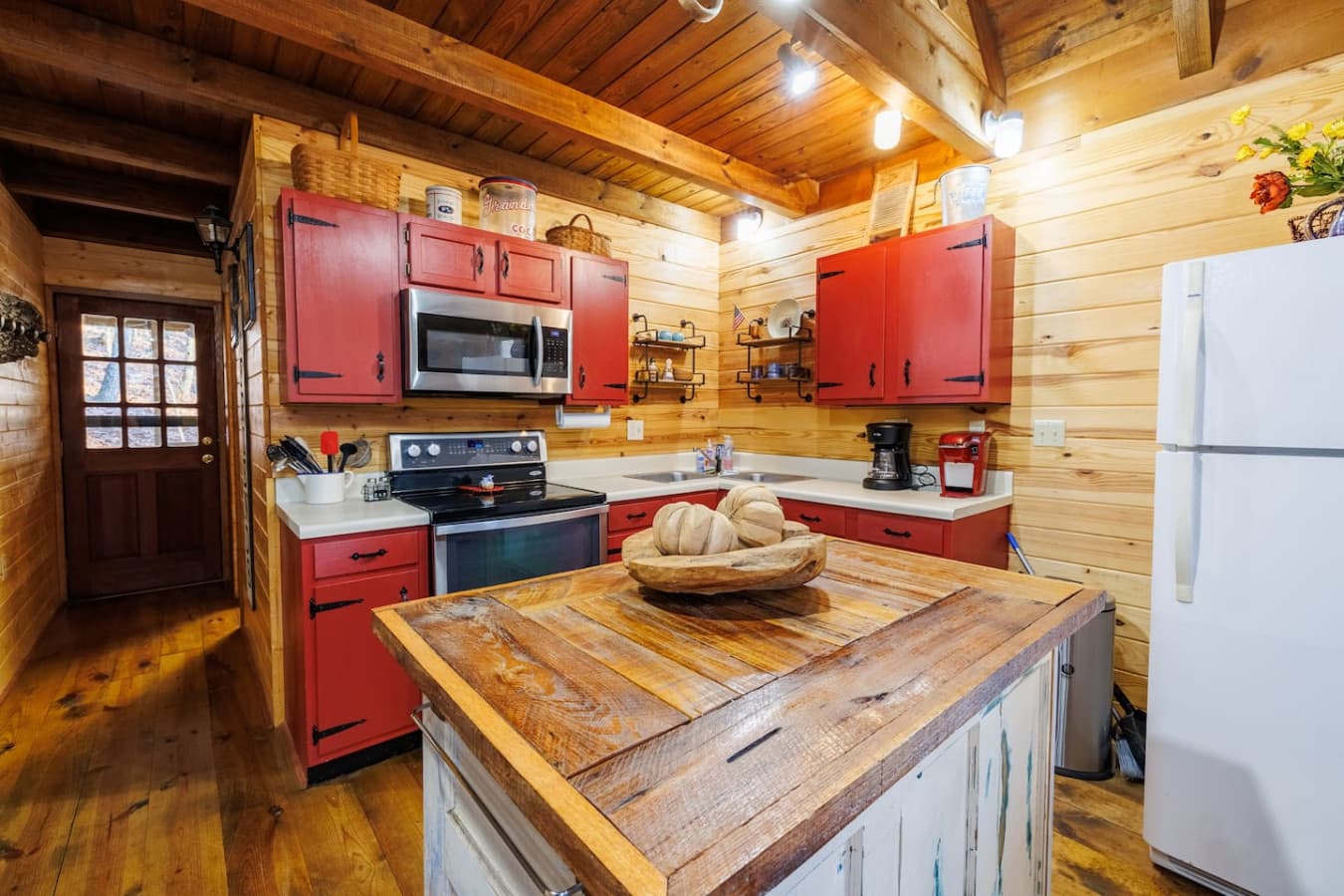 Bird's Eye View – Fully equipped kitchen with stainless appliances and rustic red cabinetry.