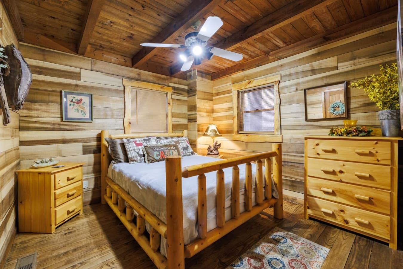 Bird's Eye View – Located in main floor, a charming wood-paneled bedroom with a queen bed and warm cabin feel.