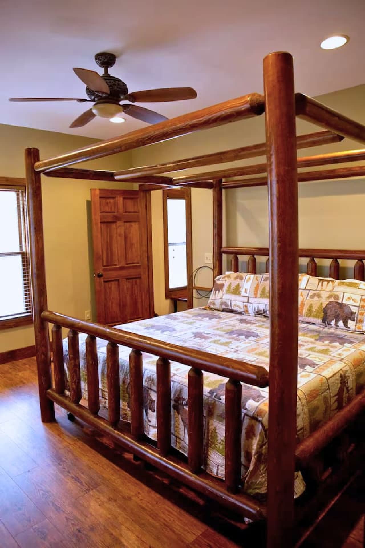 The master bedroom on the main floor features a king bed with a king sheet set, quilt, and two pillows, along with an attached bathroom.