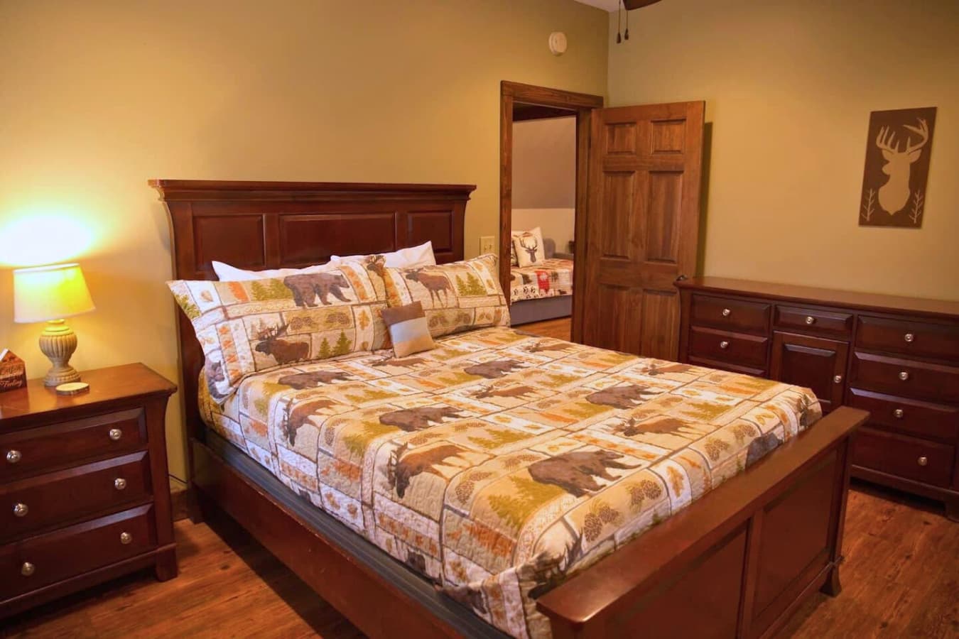Bedroom 2 upstairs features a queen bed with a queen sheet set, quilt, and two pillows, along with a dresser for storage.