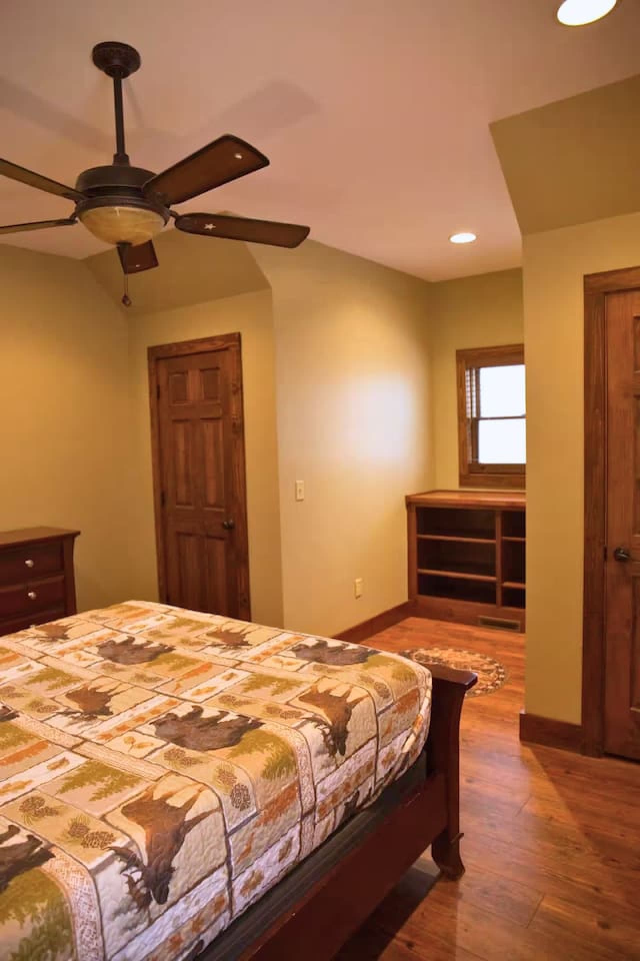 Bedroom 2 upstairs features a queen bed with a queen sheet set, quilt, and two pillows, along with a dresser for storage.