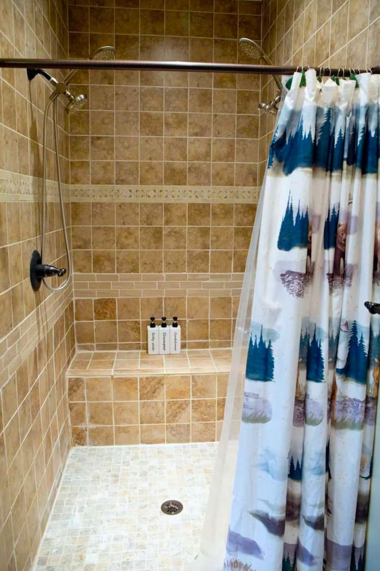 The master bathroom features a tile shower with a double shower head, a bench, and a double vanity. A toilet closet offers privacy, and the bathroom also includes a walk-in closet for added convenience.