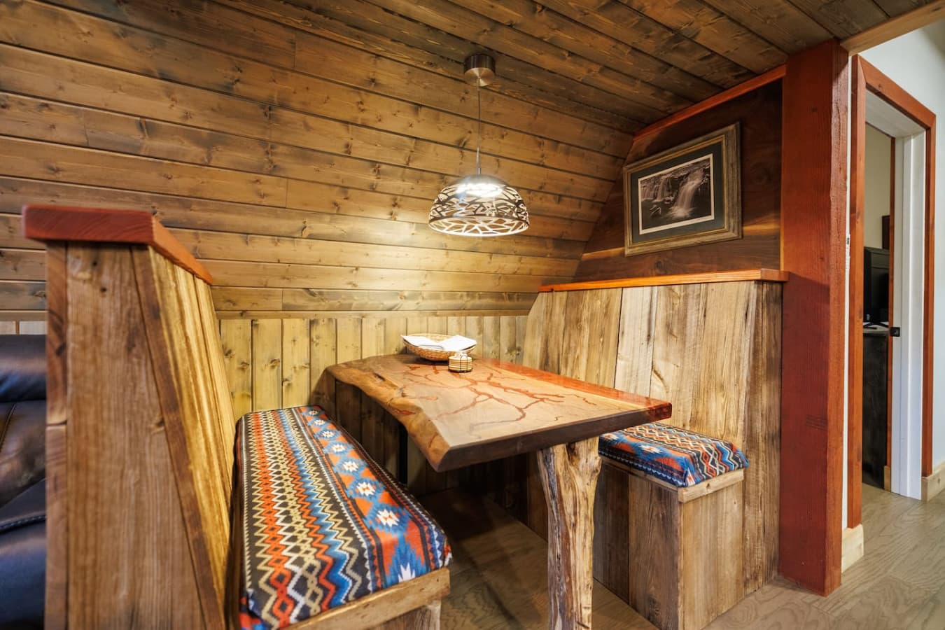 Unique dining area with a walnut table and booth seating.