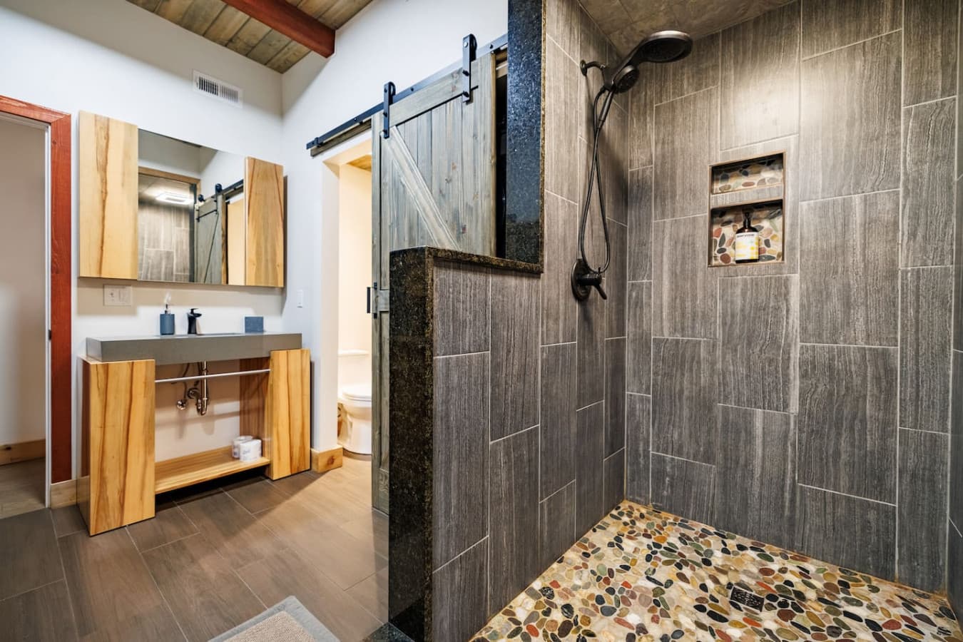 Enjoy a spacious tile shower with a rain shower head, color-changing light, and all the essentials, including towels, toiletries, and a stacked washer & dryer for added convenience.