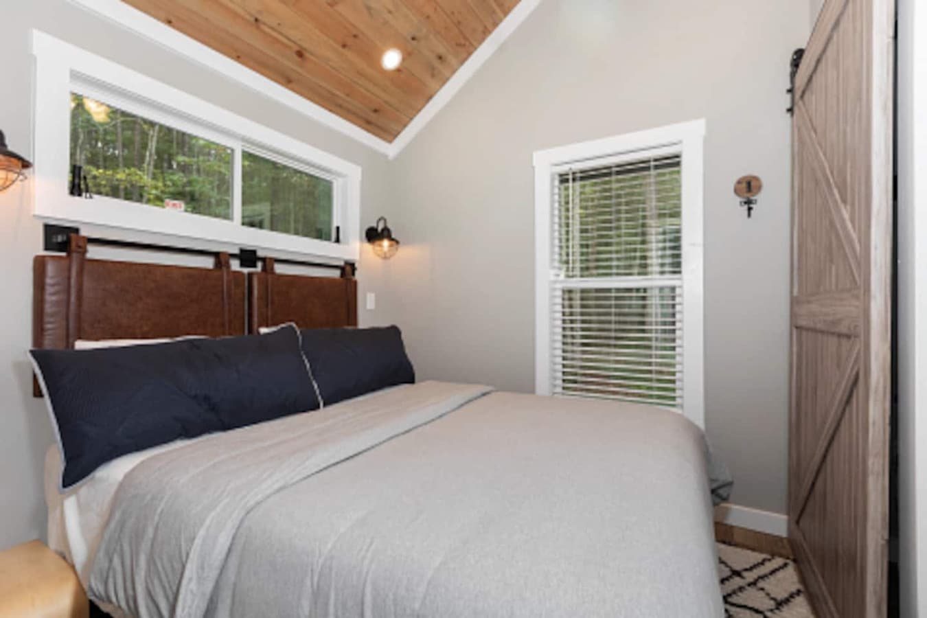 Master bedroom on the main floor featuring a queen bed with fresh linens, a closet, and a dresser for convenient storage.