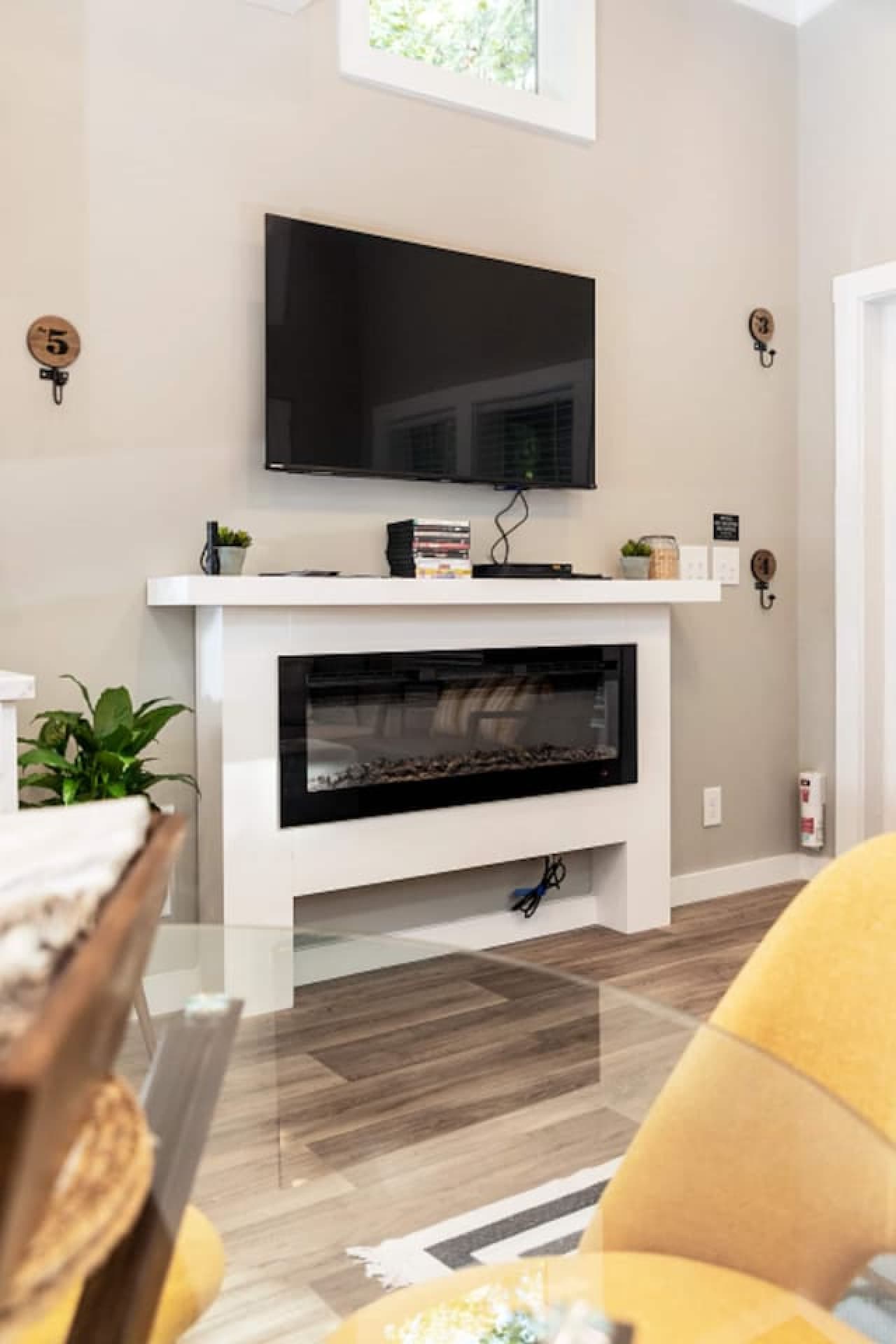 Entertainment nook featuring a wall-mounted TV, DVD player with movie selection, and a sleek electric fireplace for relaxing evenings.