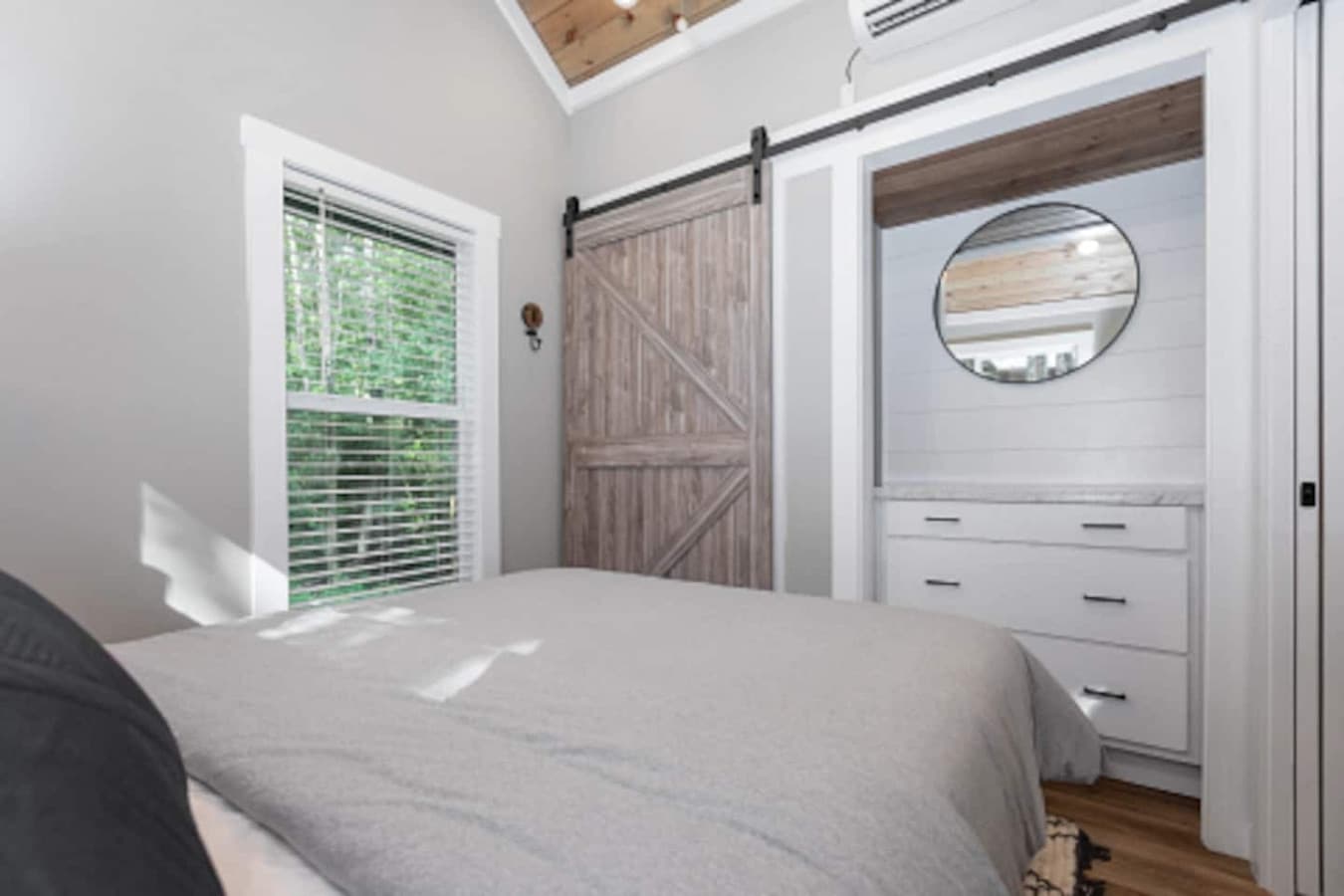 Master bedroom on the main floor featuring a queen bed with fresh linens, a closet, and a dresser for convenient storage.