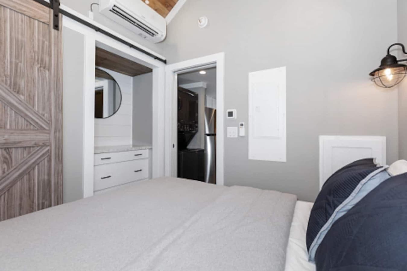 Master bedroom on the main floor featuring a queen bed with fresh linens, a closet, and a dresser for convenient storage.