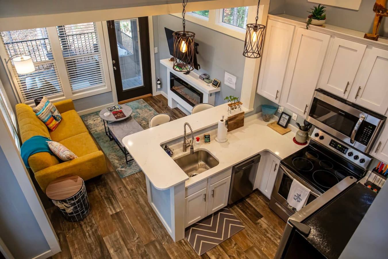 This charming open-concept space seamlessly blends the cozy living area with a fully equipped kitchen, creating a welcoming atmosphere.