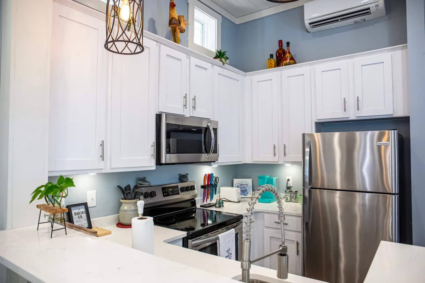 This modern kitchen combines style and function, featuring sleek white cabinetry, stainless steel appliances, and stylish decor.
