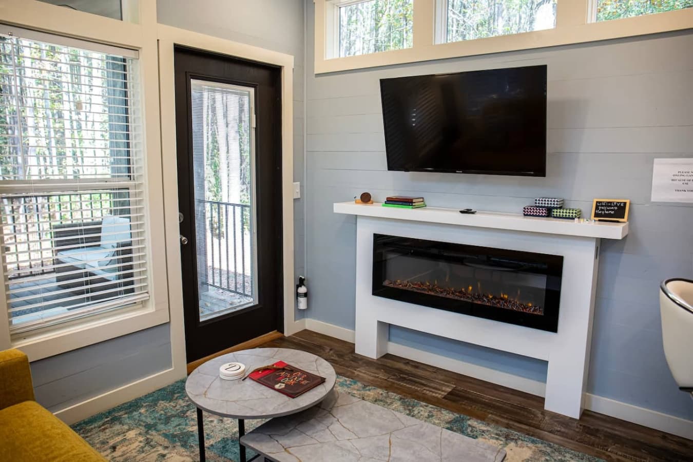 This inviting space features a modern electric fireplace, providing warmth and a cozy atmosphere, complemented by a sleek TV for relaxation.