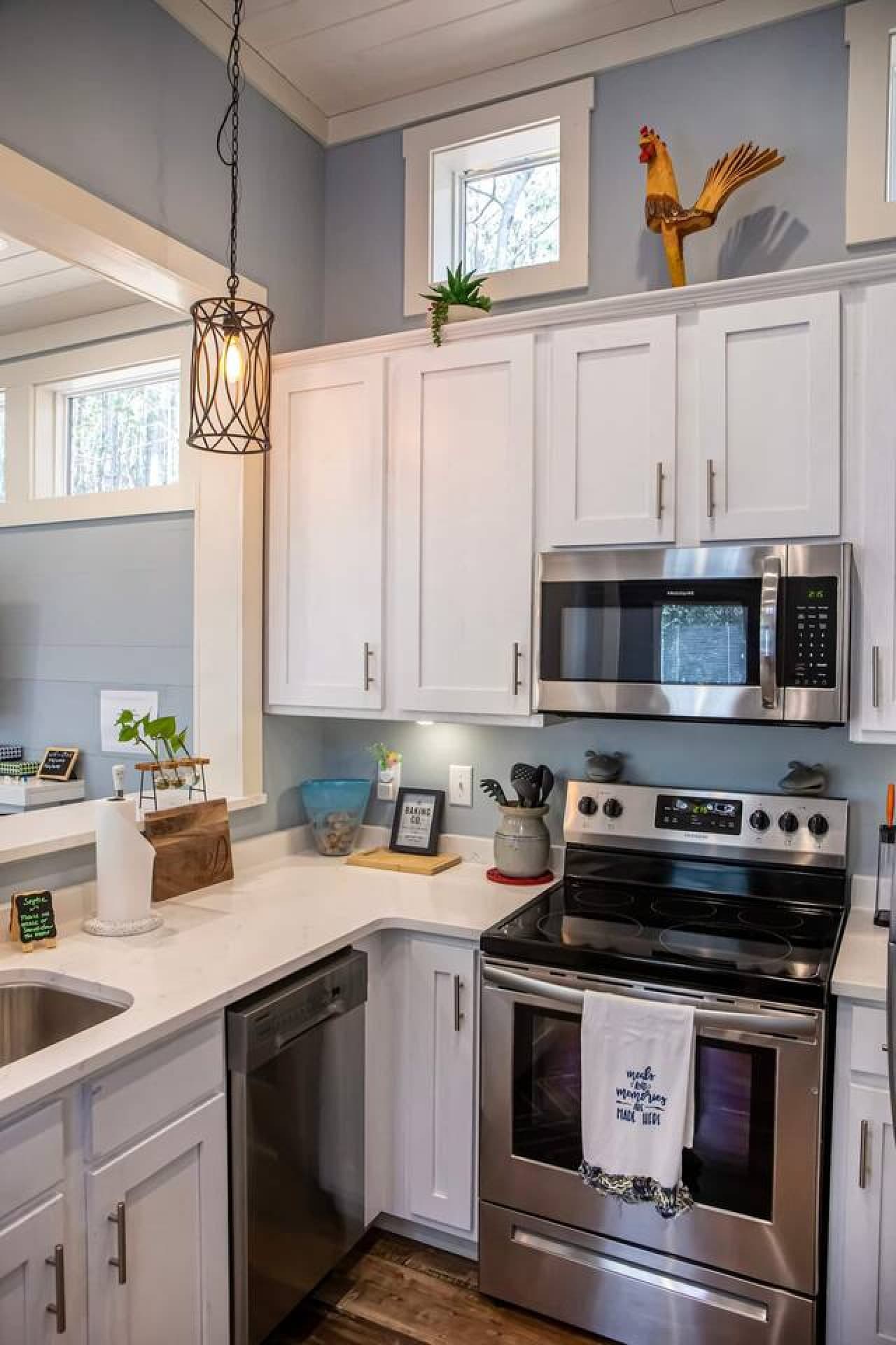 This charming kitchen is both functional and inviting, featuring sleek stainless steel appliances and crisp white cabinetry