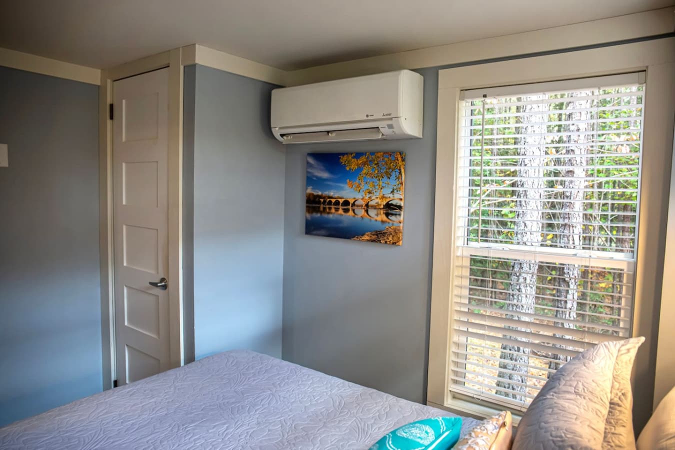 The air conditioning unit ensures a pleasant temperature, while the window with a view of the trees offers a peaceful, nature-filled atmosphere.