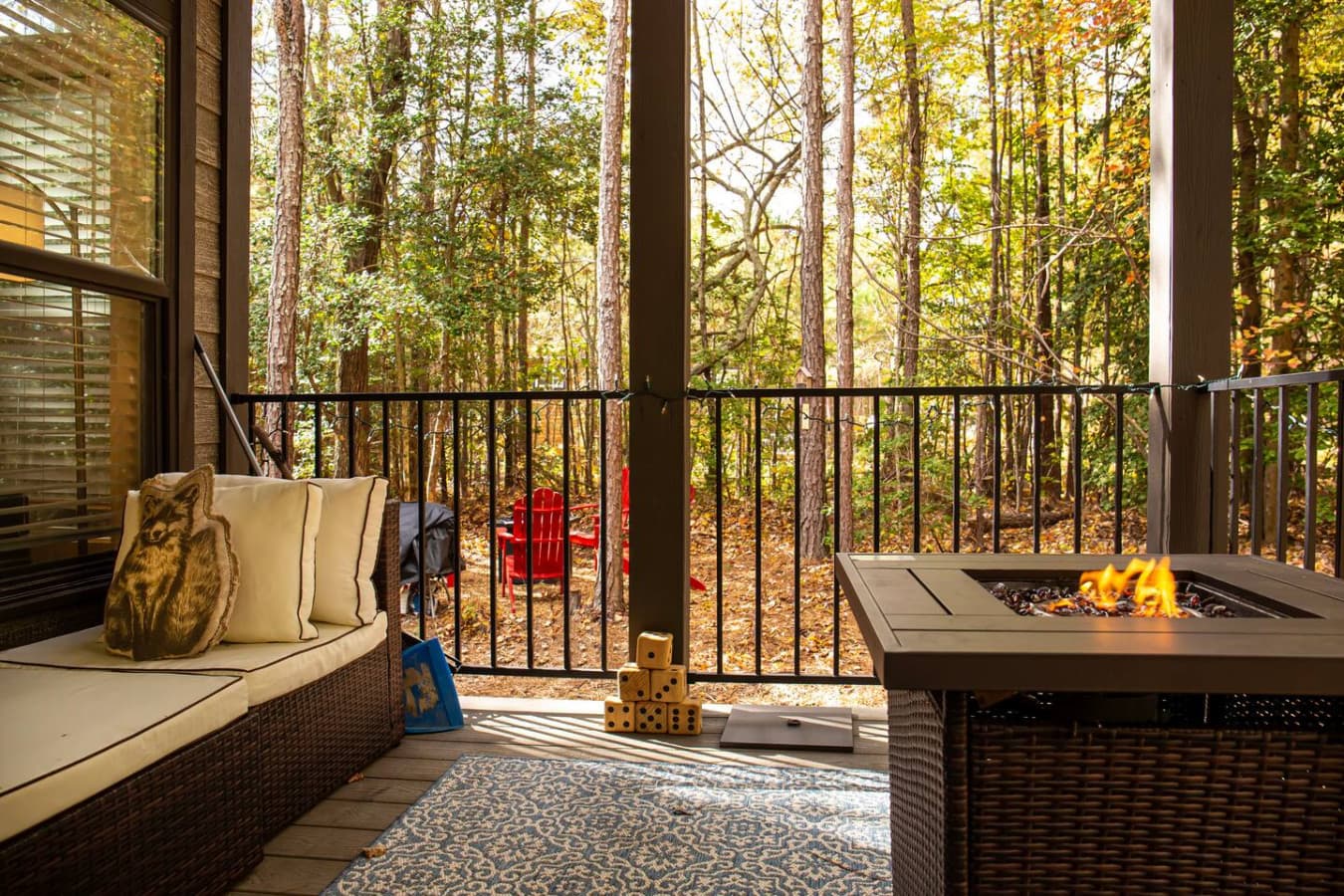 The view of the forest beyond, with a pop of red chairs in the distance, creates a peaceful and inviting atmosphere.