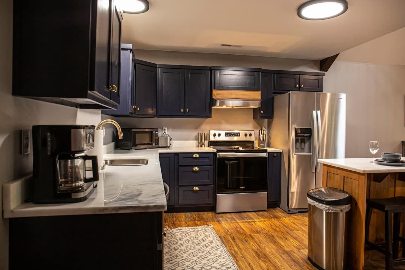 Modern kitchen: Electric Stove and Oven, Coffee Maker (Drip & K-Cup), and a center island with seating for two.