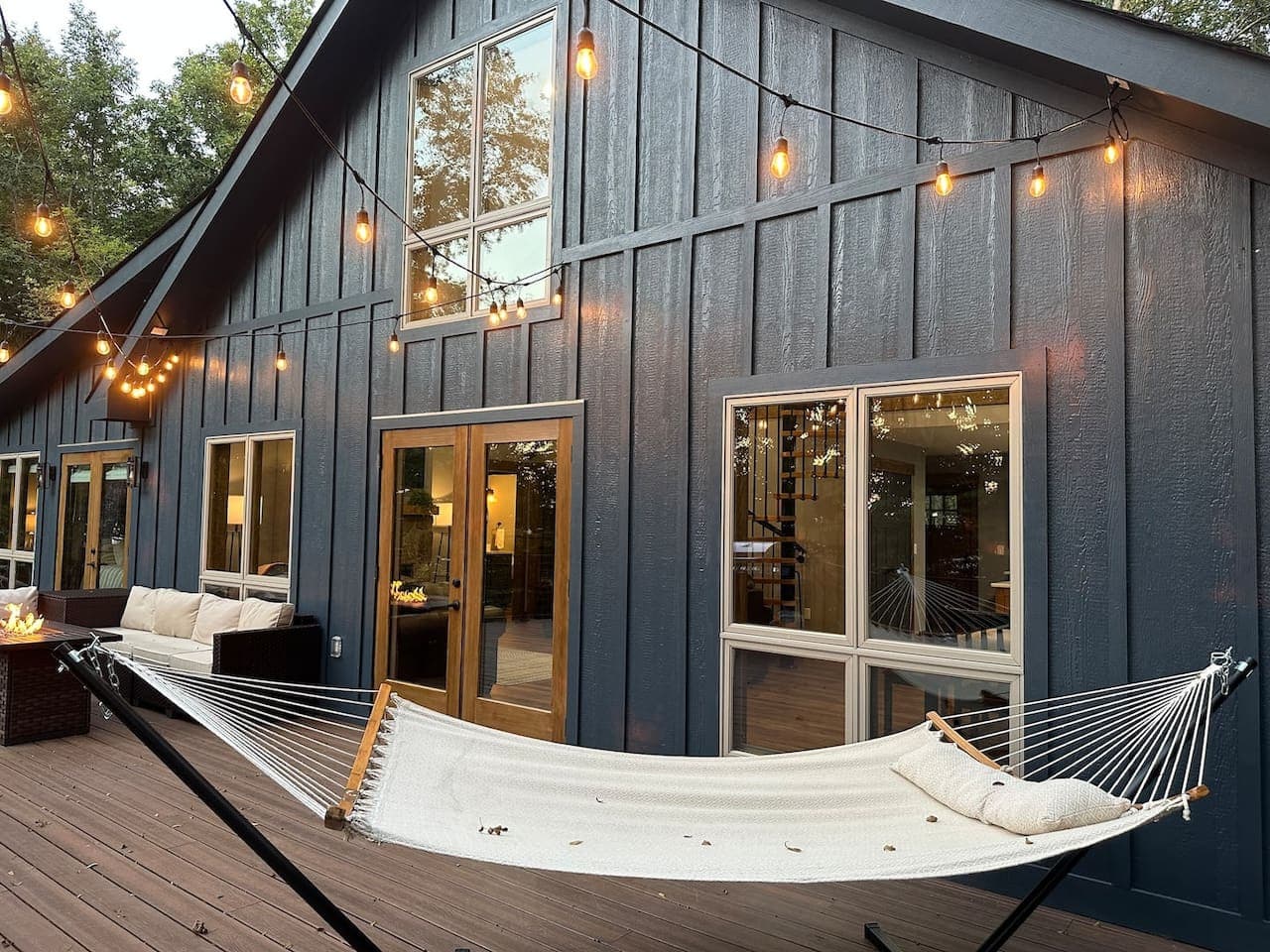 Spacious back deck with string lights and a relaxing hammock—ideal for unwinding under the stars.
