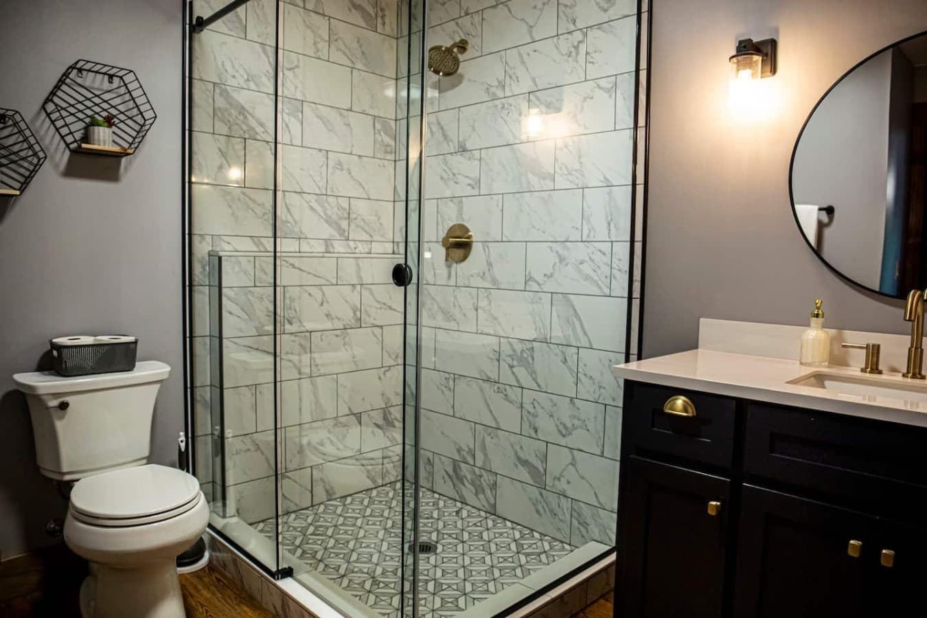 Featuring a glass walk-in shower, modern vanity, and stylish gold fixtures. One Towel and One Wash Cloth Provided