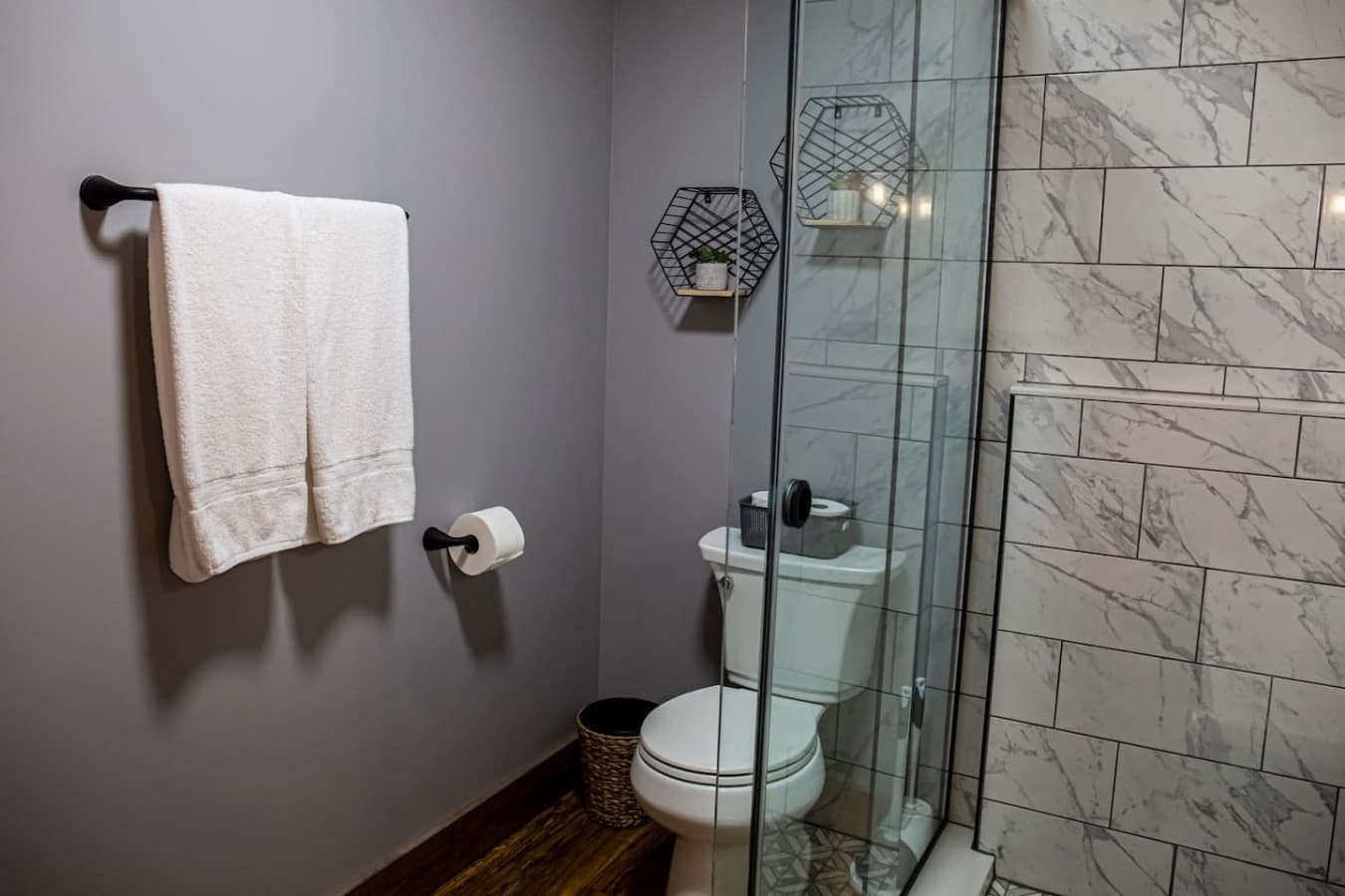 Featuring a glass walk-in shower, modern vanity, and stylish gold fixtures. Toilet and 2 Rolls of Toilet Paper Provided