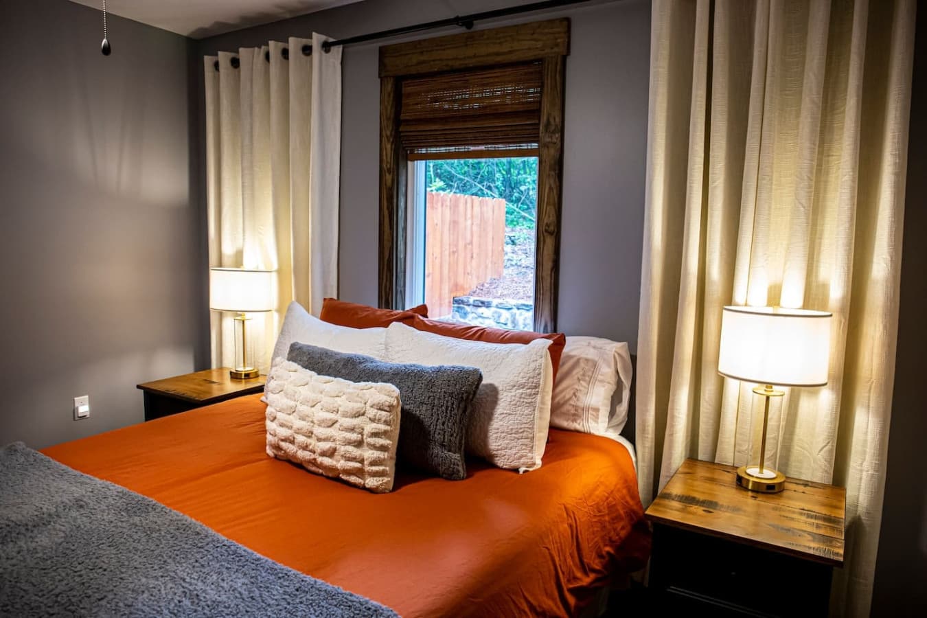 Bedroom 2 with a cozy queen bed, warm lighting, and soft linens for a comfortable night’s rest.