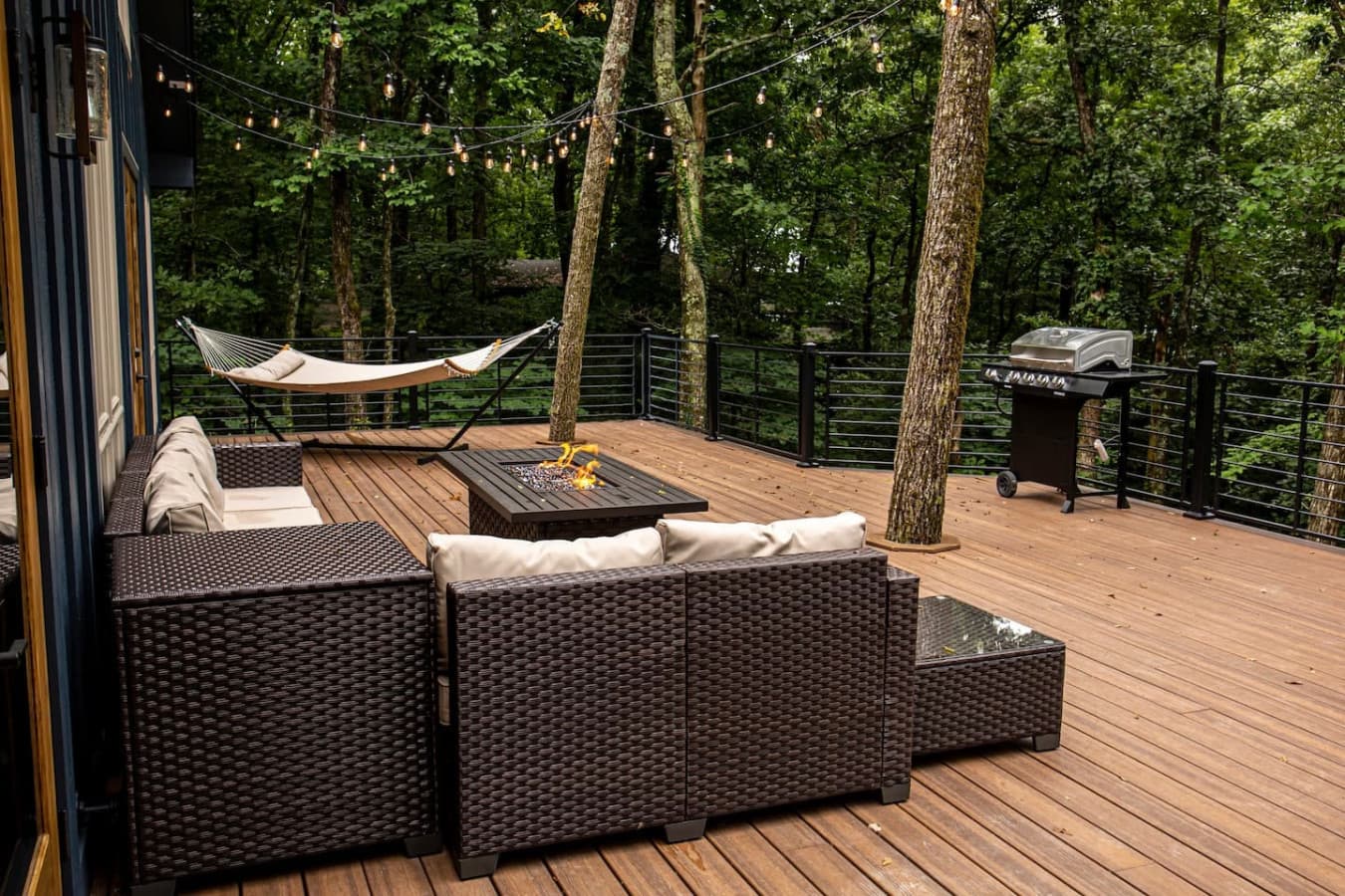 Large back deck with sunset views, featuring a cozy propane fire pit and relaxing hammock.