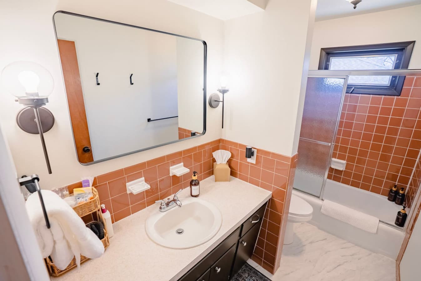 Vanity area includes mirror and lighting for daily use.
