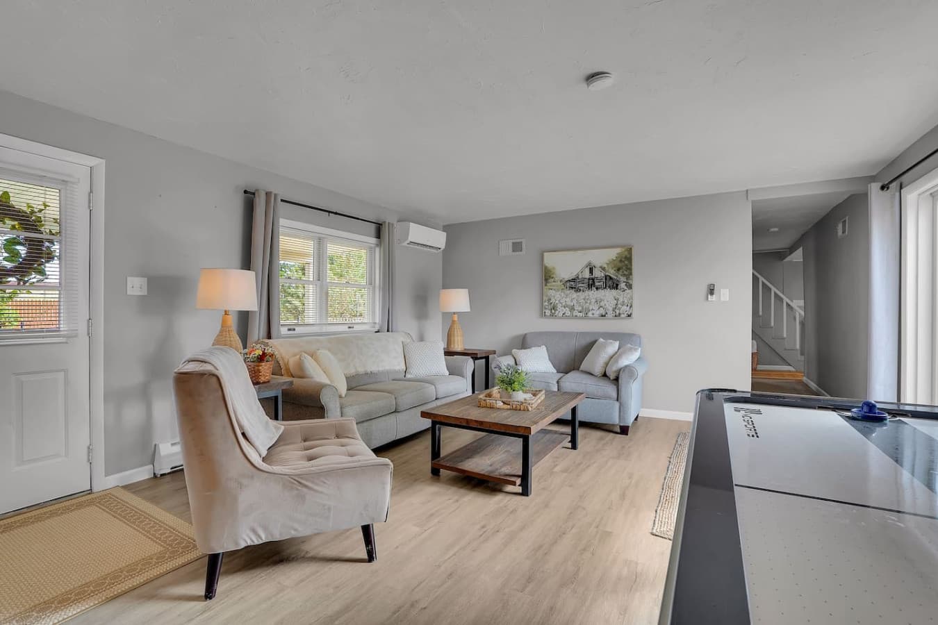A bright and airy living space filled with natural light, offering cozy seating and a relaxed atmosphere for unwinding.