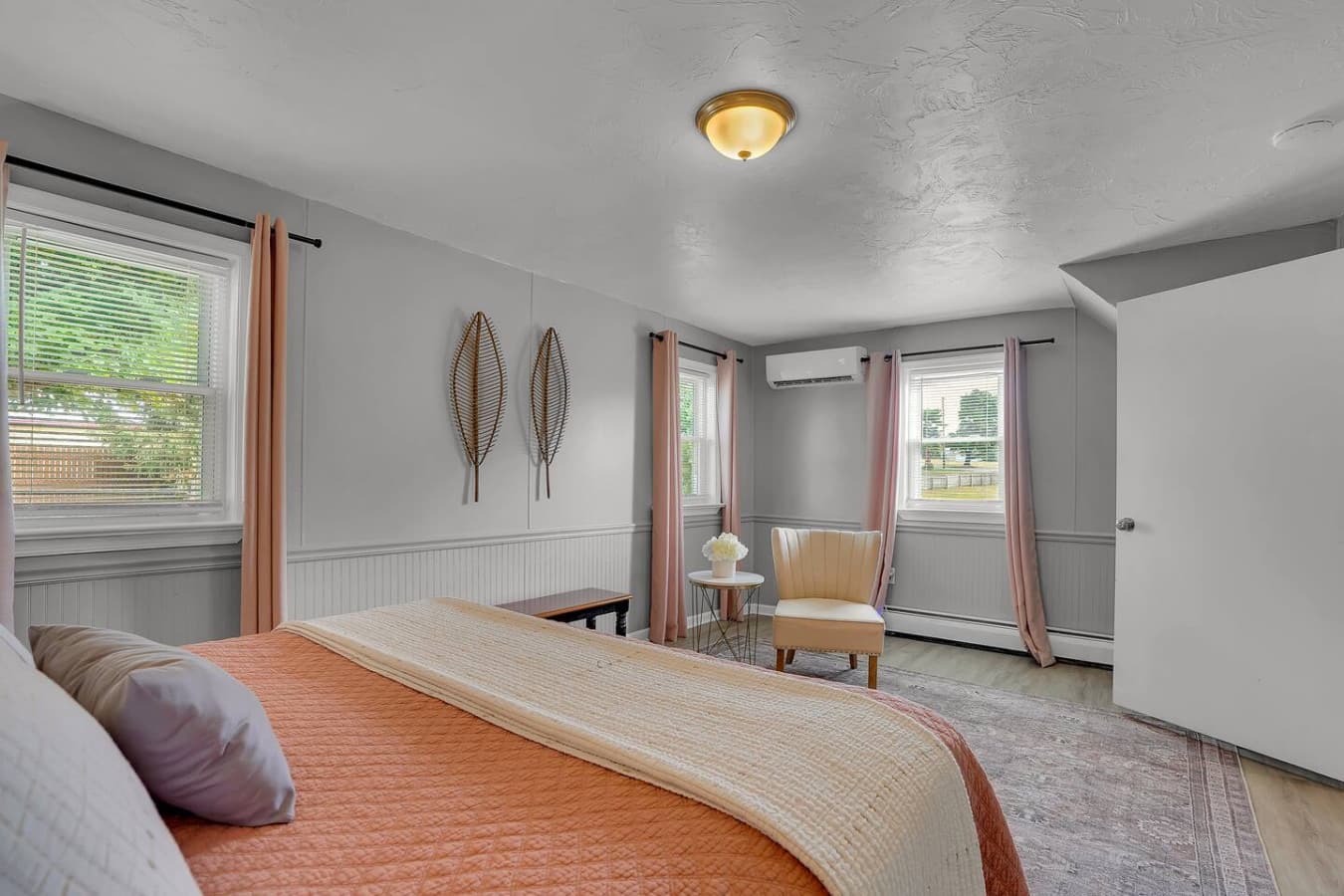 A spacious bedroom with plenty of natural light, offering a comfortable bed and a soothing environment for a restful stay.