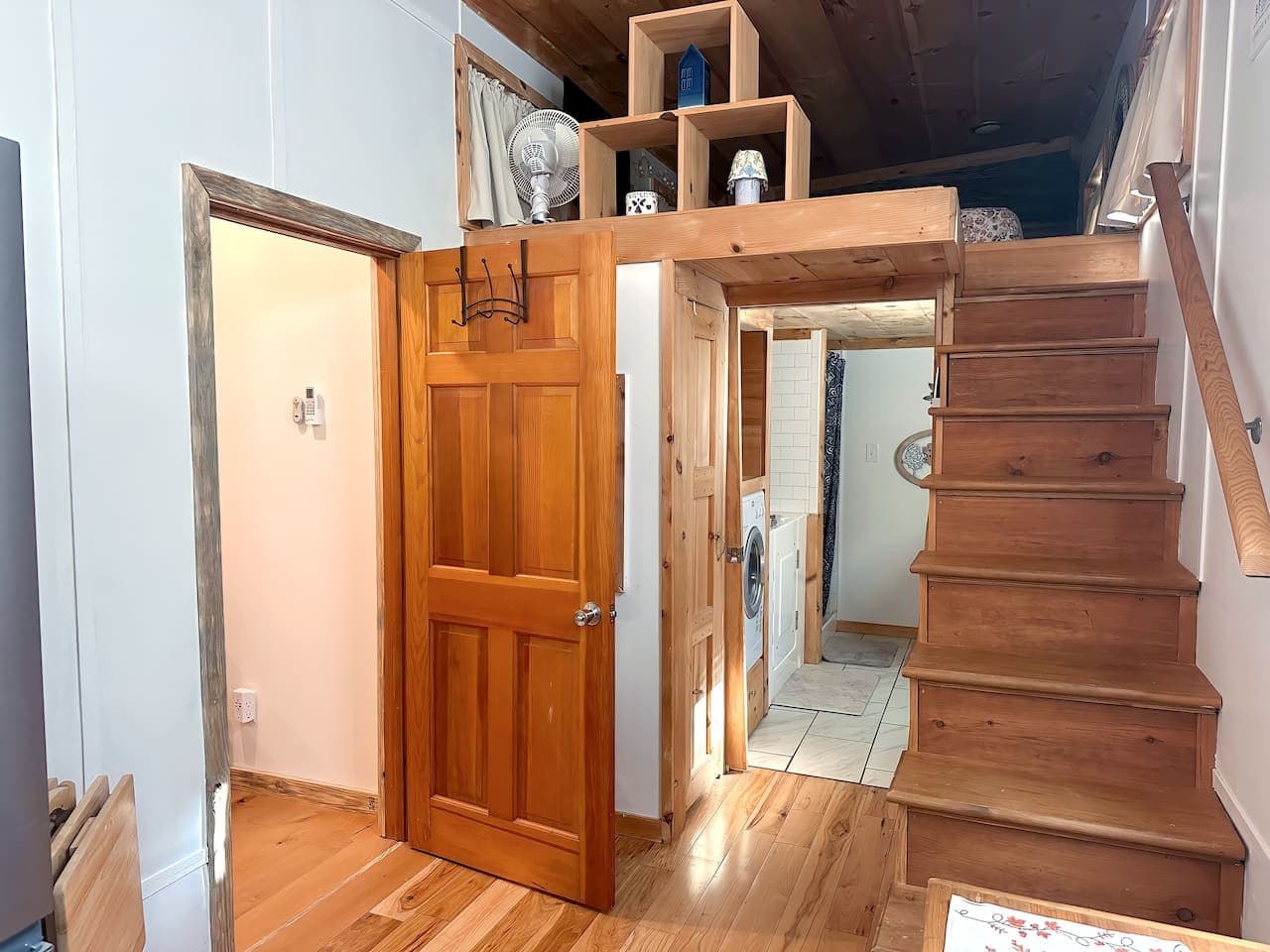 Stairs lead to the bedroom and hallway, which provides access to the bathroom.