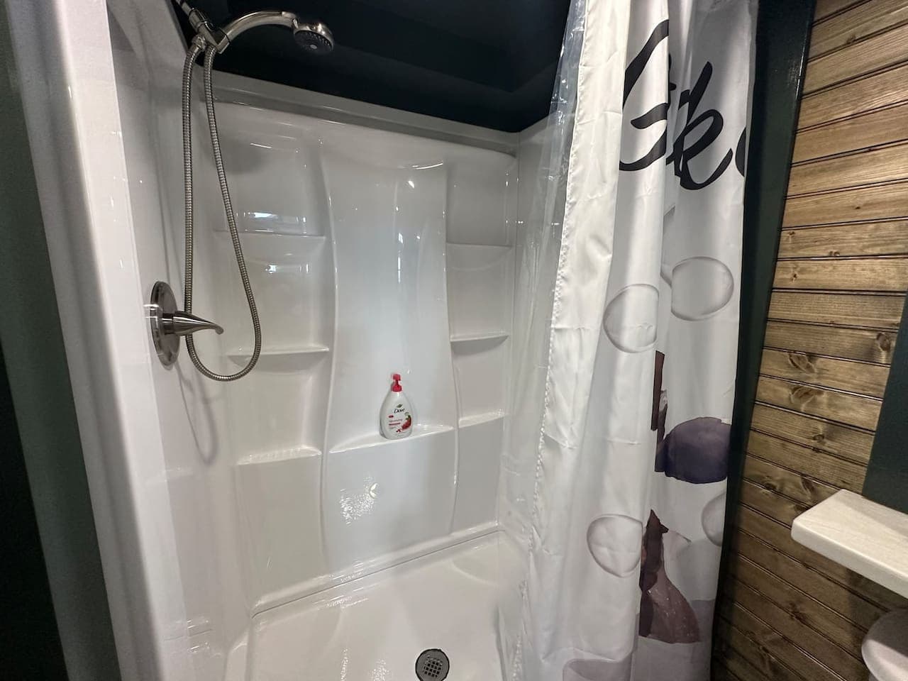 The recently renovated bathroom features a shower. It has two entrances: one from the master bedroom and another from the living room.