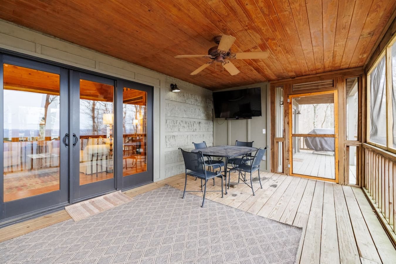 Outdoor dining table with a smart TV and cable on the porch off the living room.