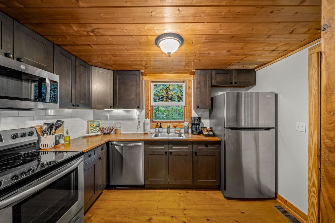 Dishwasher, sink, refrigerator and door to the right leading to covered back porch.