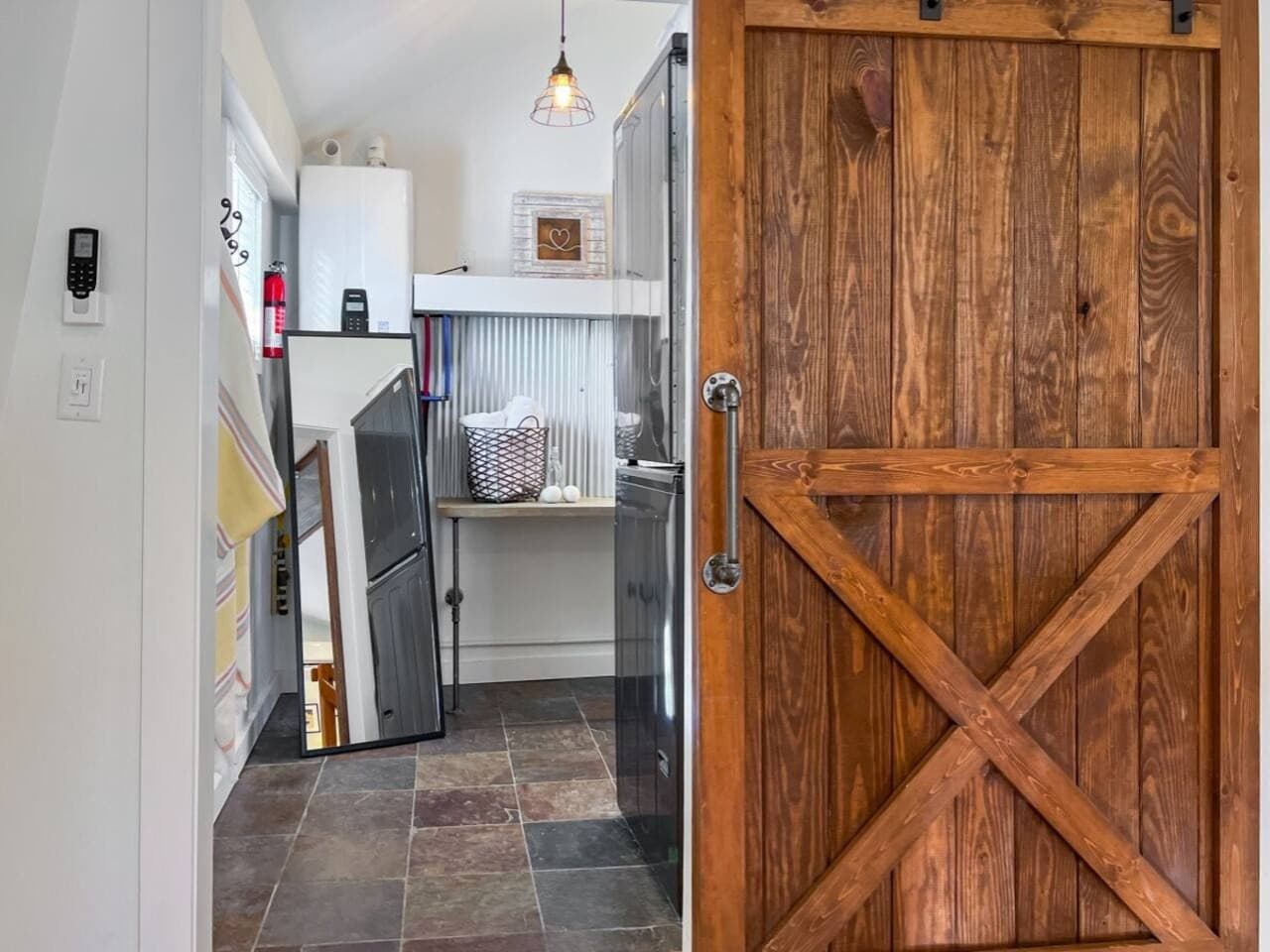 Open the barn door to a luxe farmhouse bathroom - with its own washer/dryer!